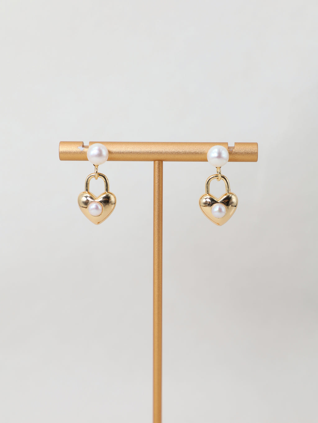 Sweetheart Earrings displayed on a jewelry stand