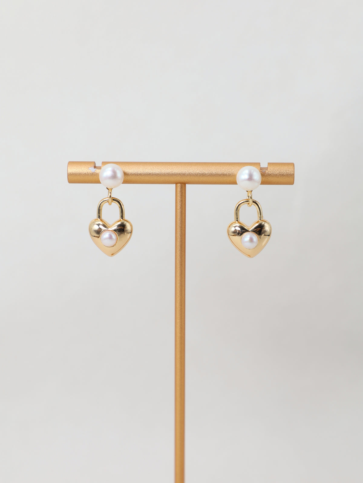 Sweetheart Earrings displayed on a jewelry stand