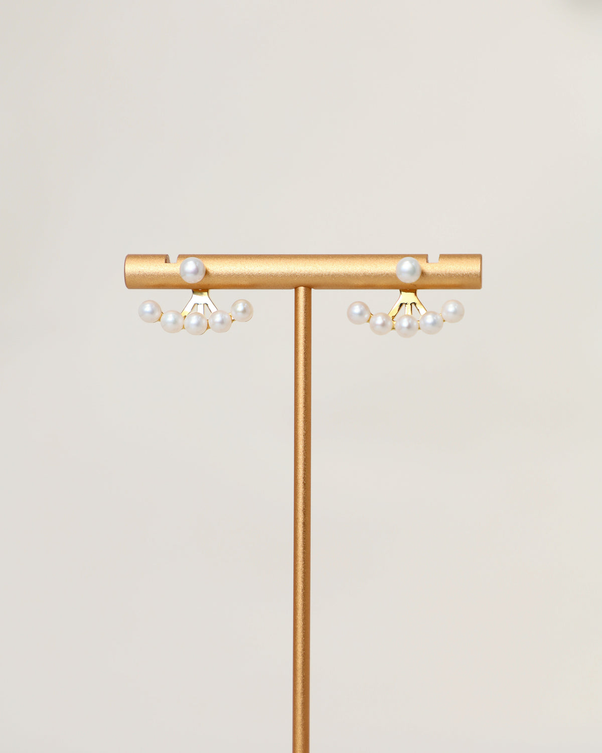 Fanfare Earrings displayed on a jewelry stand