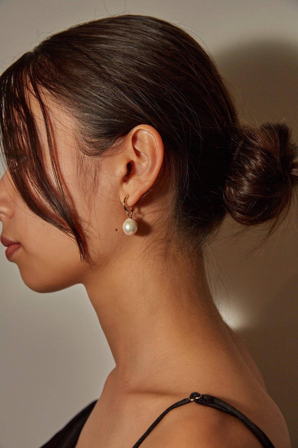 A pearl drop earring worn with a swept-back hairstyle. Illustrative photograph, not a 6mm and 9mm size comparison.